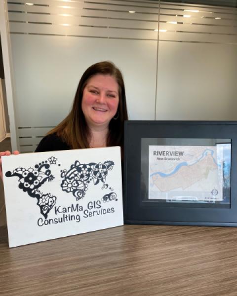 GIS Consultant standing with map and sign