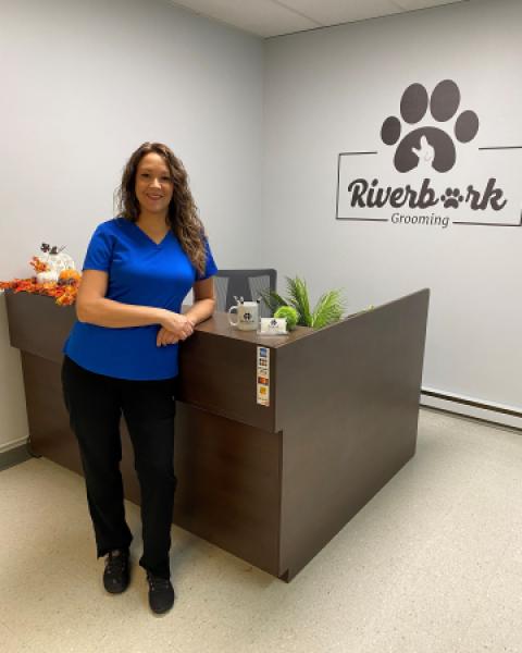 Owner of Riverbark grooming standing by counter