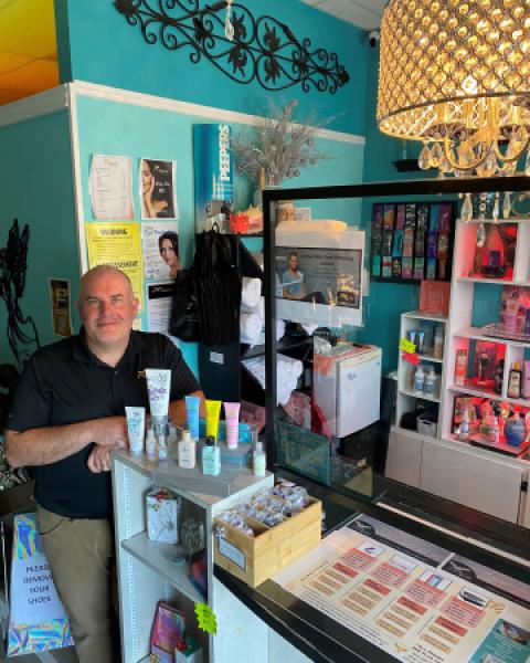 Owner standing by checkout counter at salon