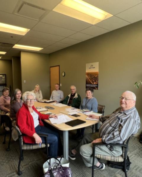 Seniors sitting around a table in a meeting room