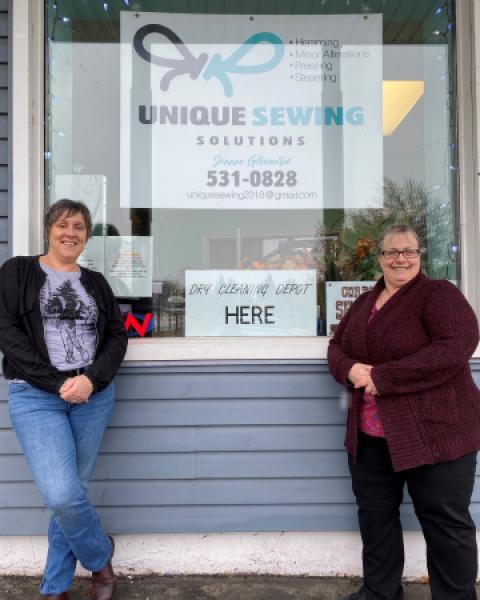 Two women standing outside business