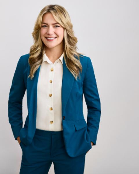 A smiling woman in a blue suit