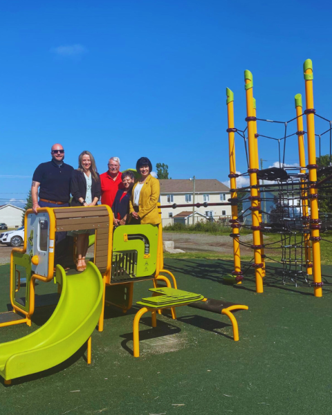 Members of Council stand on play equipment with Minister Ginette Petitpas Taylot