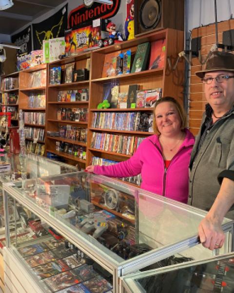 A couple standing behind display case in a buy, sell, trade shop