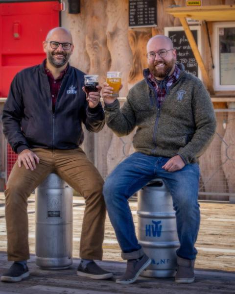 Pete and Jeff Grandy cheers a beer on the patio of Holy Whale Beer Hall