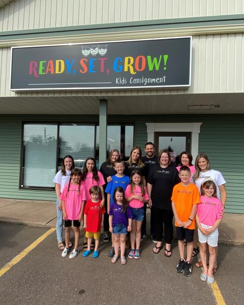 Business owners and their families standing outside of storefront