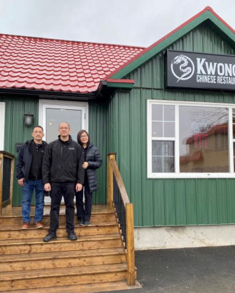 Restaurant owners standing on steps outside of building