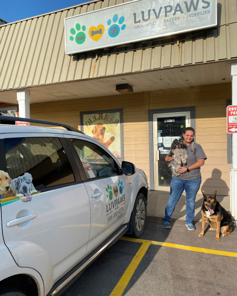 Luv Paws owner Vicky outside her storefront with two dogs