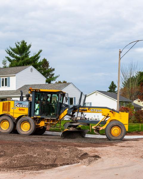 Two trucks working on a residential street
