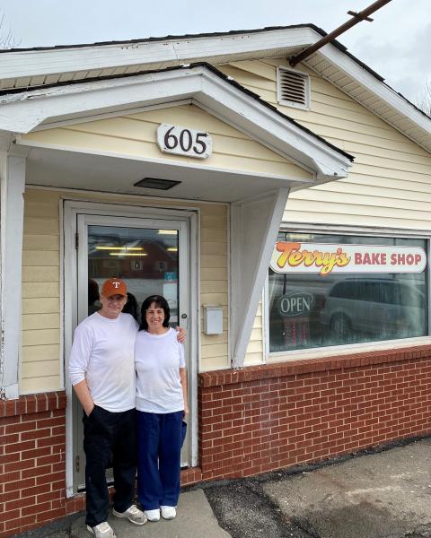 man and woman stand outside bake shop