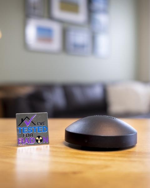 black radon detector sits on table in living room