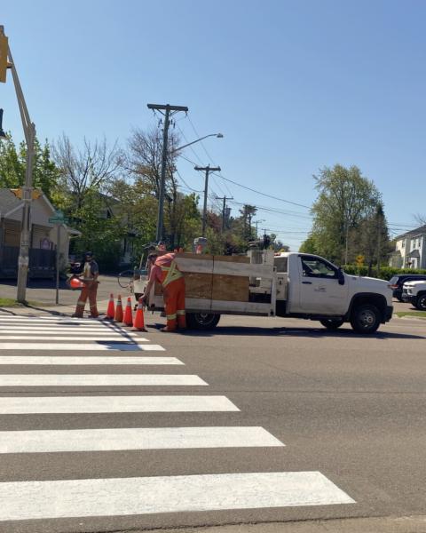 A Riverview truck and two staff line painting a crosswalk