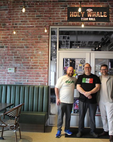 Three business owners smiling and standing together