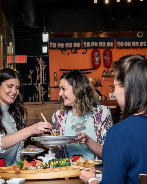 4 women at a table enjoying a meal at a local restaurant.