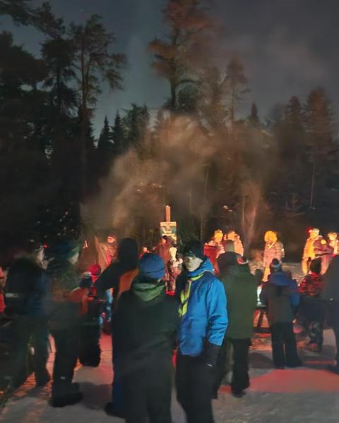 People gathered around a campfire in Mill Creek Nature Park.