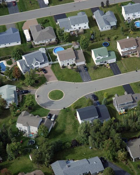 Aerial view of a residential neighbourhood with houses, streets, and trees