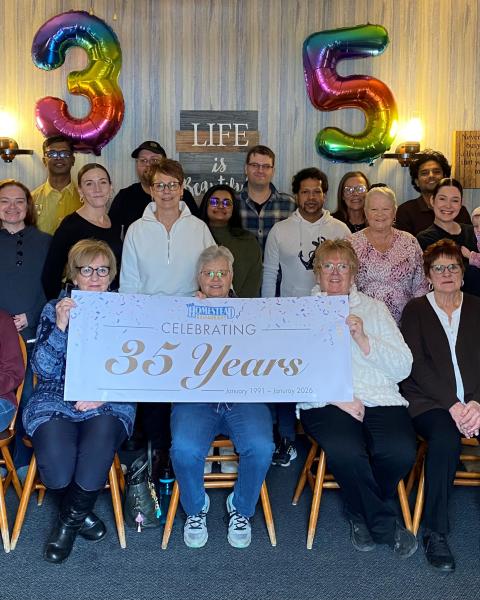 The Homestead staff pictured with a 35th Anniversary banner and balloons. 