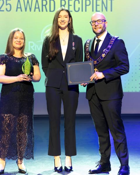 Mayor and award presenter present an award to the recipient.