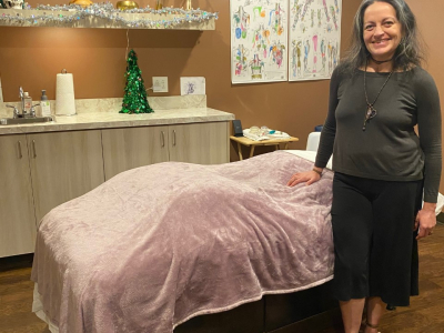 woman stands next to massage table