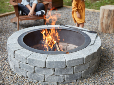 A concrete fire pit with flames in the centre. 