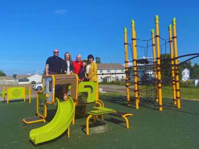 Members of Council stand on play equipment with Minister Ginette Petitpas Taylot