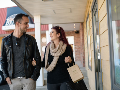 man and woman walk past riverview shops