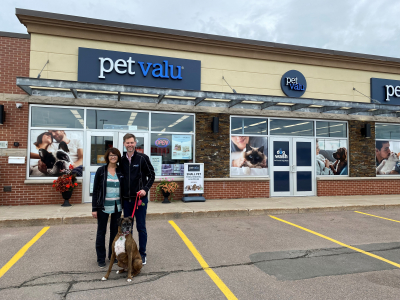 new pet valu owners stand outside store with dog