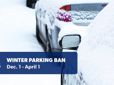 Cars covered in snow are parked at a street curb. Graphic overlay reads "Winter parking ban December 1 to April 1"
